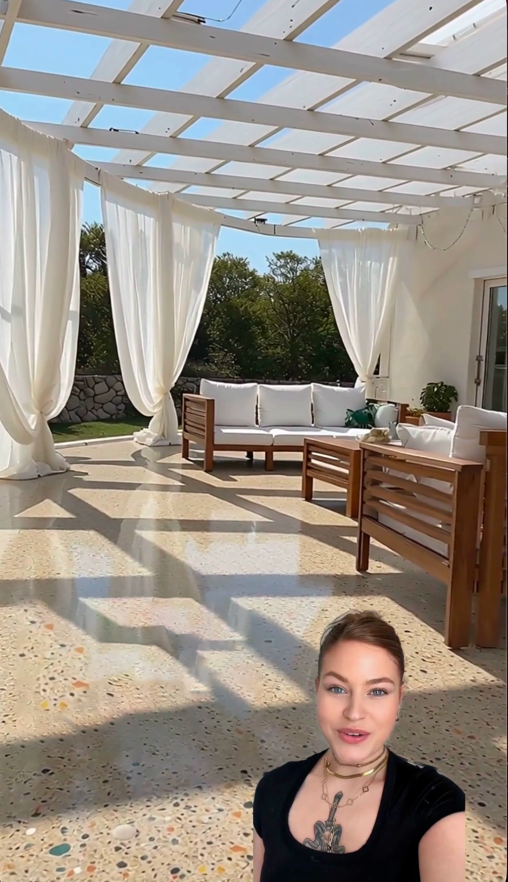 Presenter standing on a finished concrete patio beneath a bright pergola